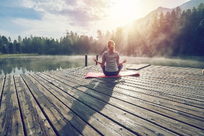 woman meditating on a dock