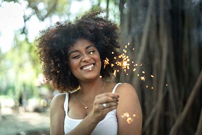 Woman smiling, holding a sparkler