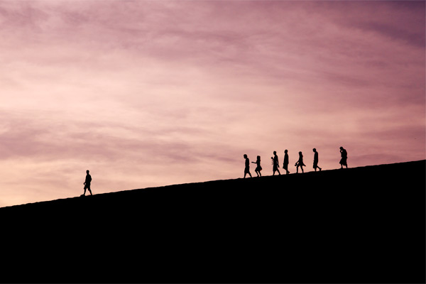 people walking against sunset